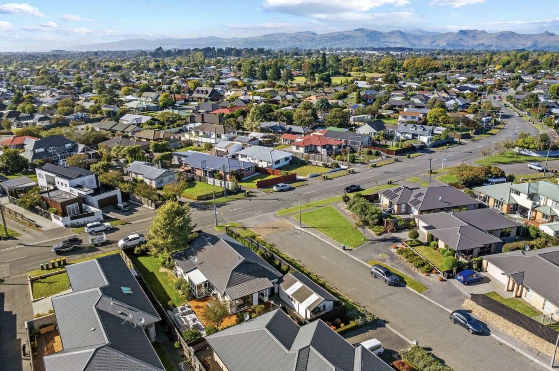 Aerial view over Burwood residential streets with the Southern Alps in the distance