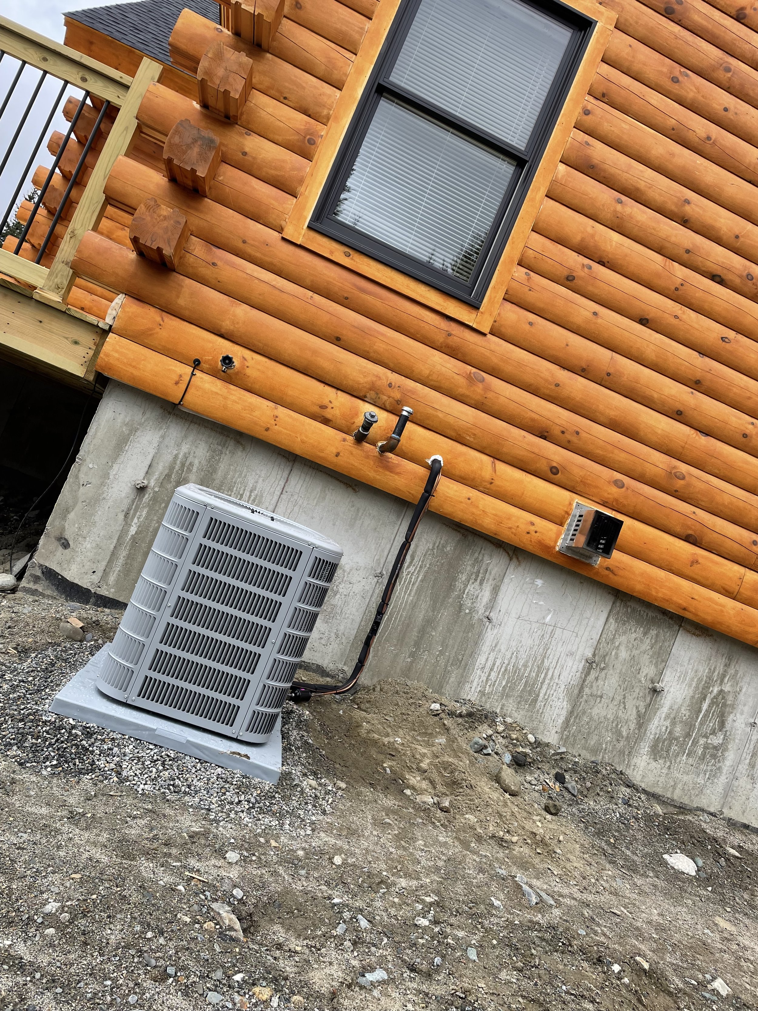 Central air conditioning condenser installed beside a residential home by Sutton Heating and Air