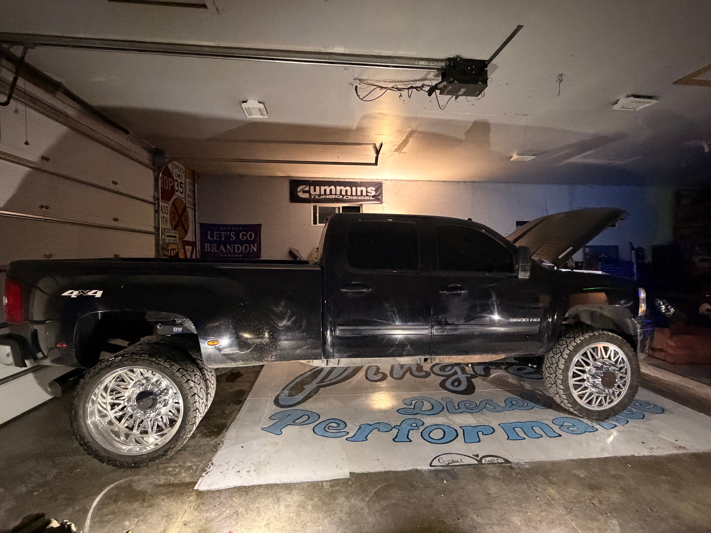 Side view of a black dually pickup inside the shop.