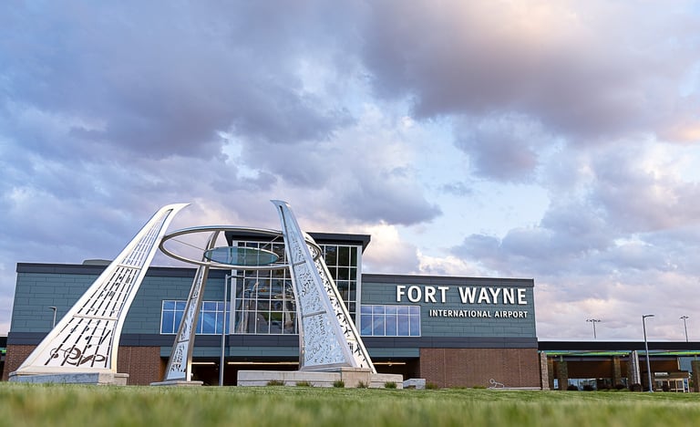 Fort Wayne International Airport terminal with a modern metal sculpture out front.