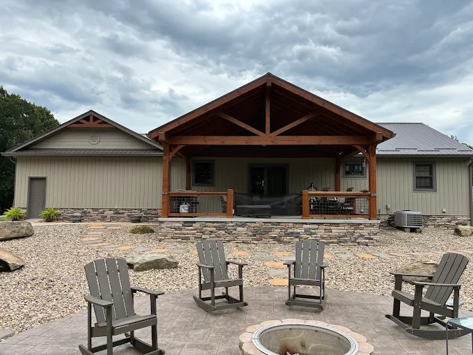 Covered timber frame porch with king post truss and stone patio by Sunrise Builders 4 LLC in Rutledge, TN