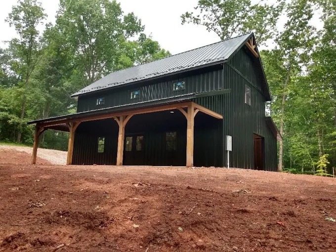 Residential barndominium with timber frame covered porch and metal roof in East Tennessee by Sunrise Builders 4 LLC