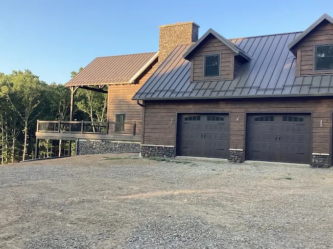 Custom timber frame home with standing seam metal roof and stone accents in Rutledge, TN by Sunrise Builders 4 LLC