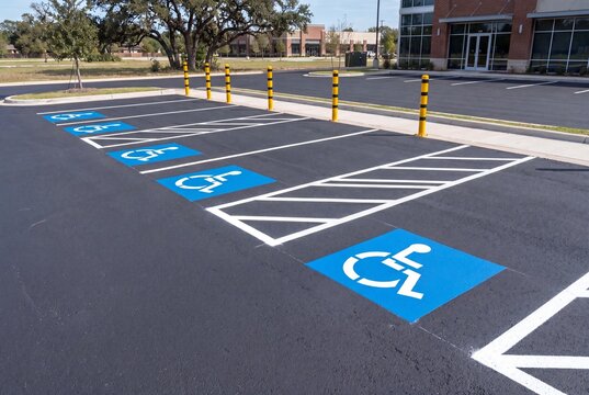 ADA-compliant accessible parking stalls with brilliant blue painted handicap symbols and crisp white diagonal access aisles
