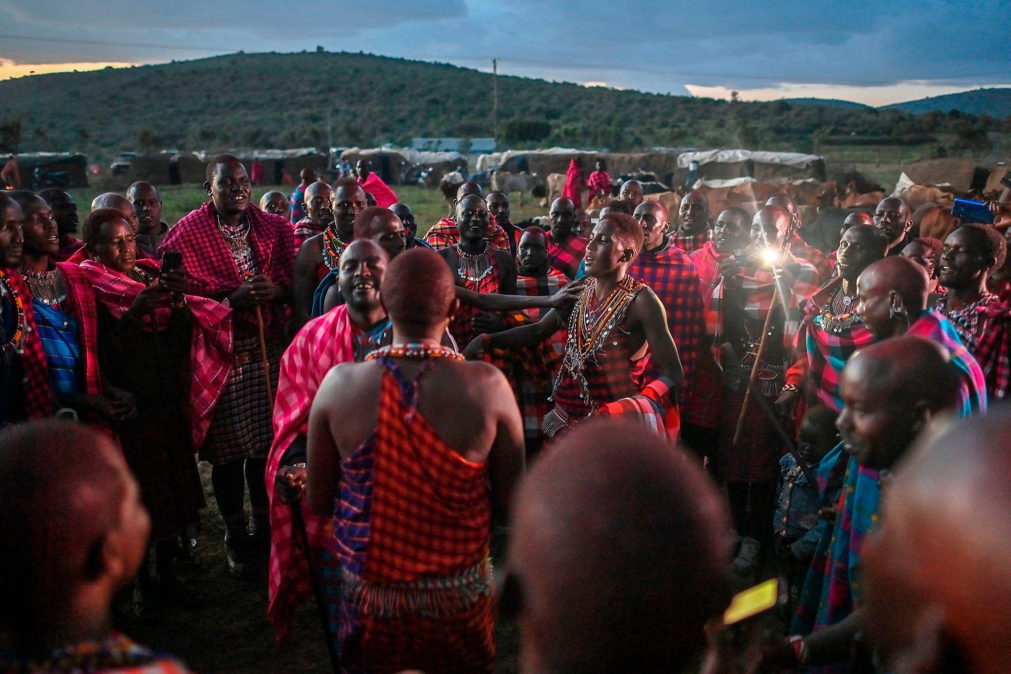 Dancers in traditional dress in a dusk festival crowd with African Beat drummers