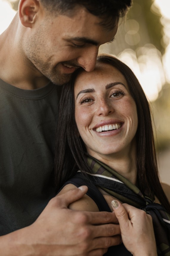 Retrato íntimo y natural de pareja sonriendo abrazados