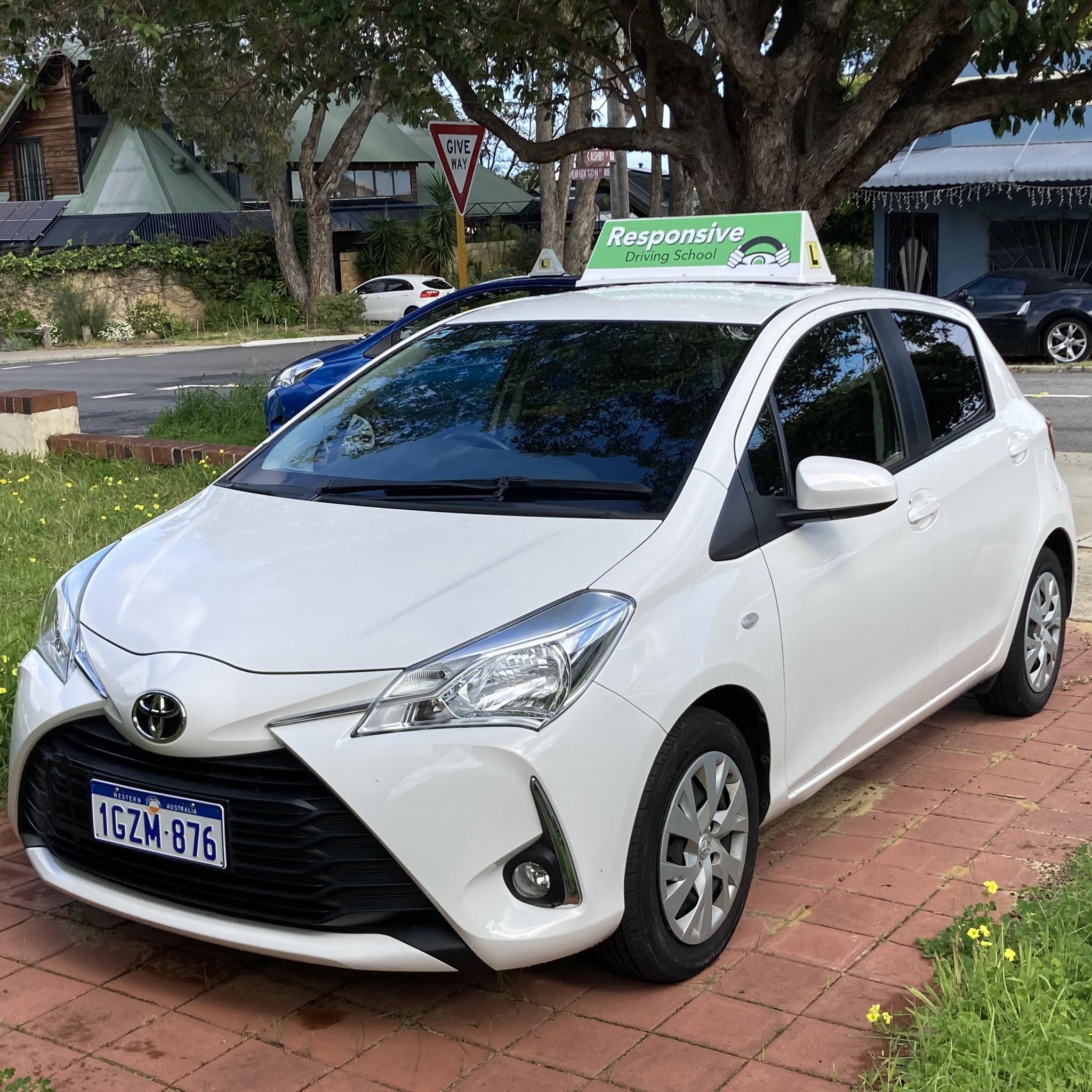 White Toyota Yaris training vehicle with green Responsive Driving School roof sign