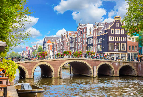 Amsterdam brug met bloemen over de gracht en karakteristieke grachtenpanden