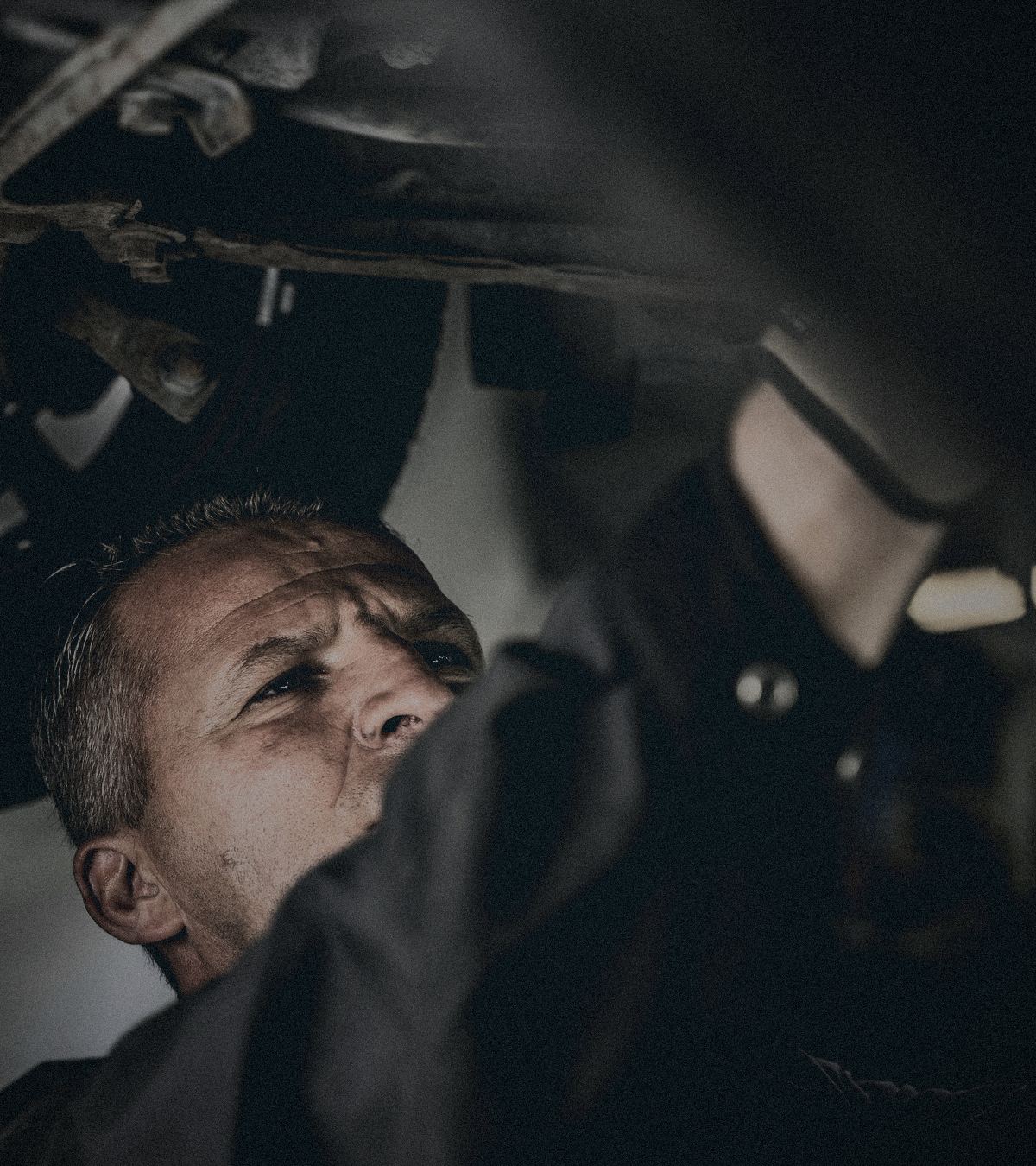Auto mechanic working underneath a car