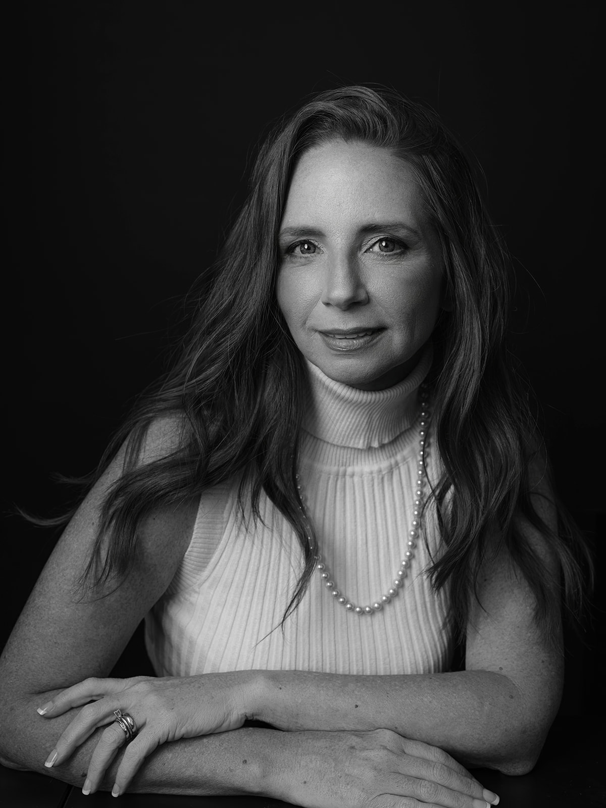 Black and white portrait of a smiling woman with pearls by Elisa Mitchell Studios