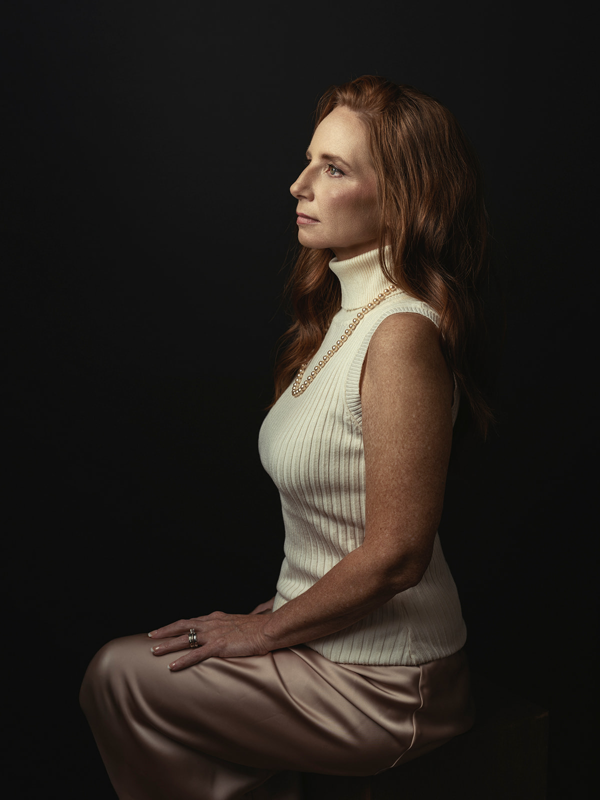 Portrait of a woman with pearls in dramatic light by Elisa Mitchell Studios