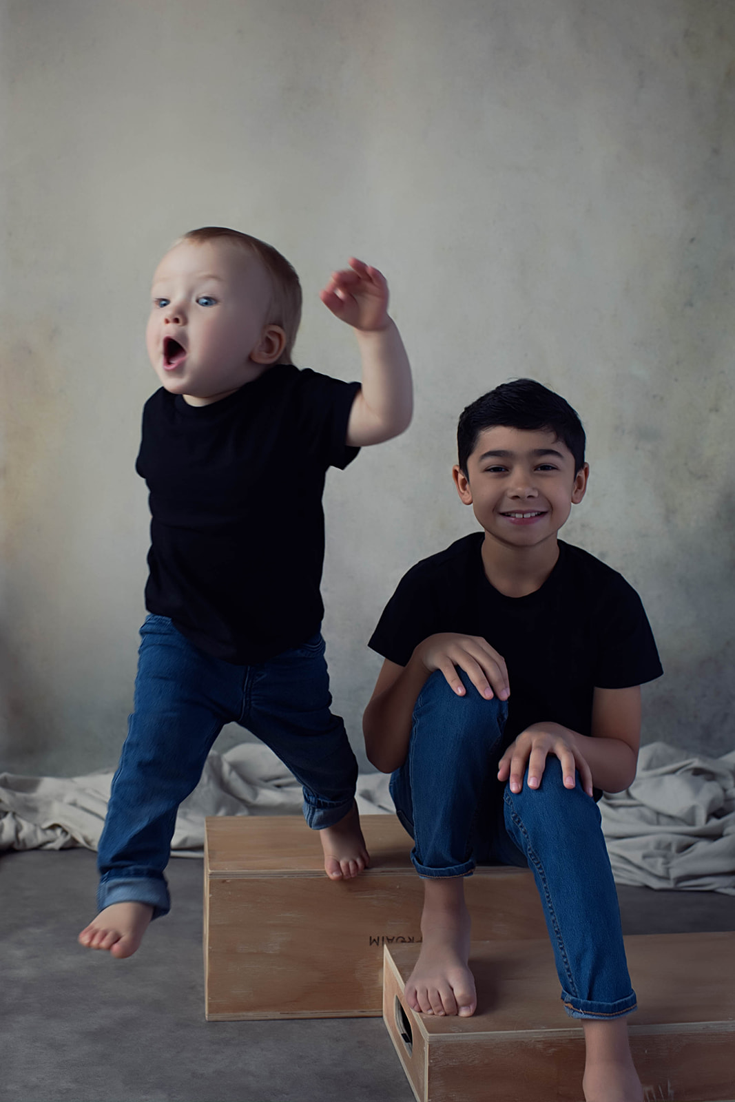 Studio portrait of two young brothers in jeans and black shirts by Elisa Mitchell Studios