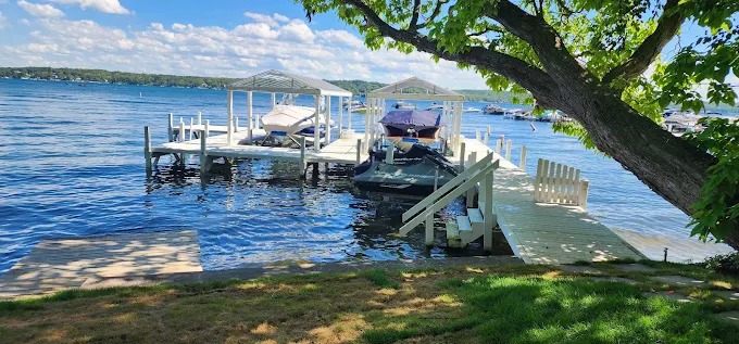 Finished white dock and pier system with boat slips on a calm Wisconsin inland lake