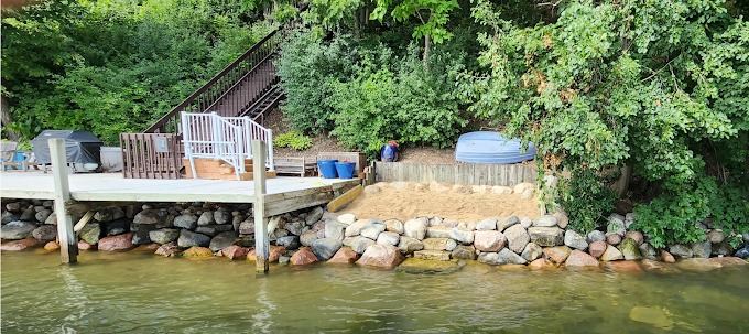 Shoreline seawall with riprap stone toe and lakefront lawn stairs on a Wisconsin lake