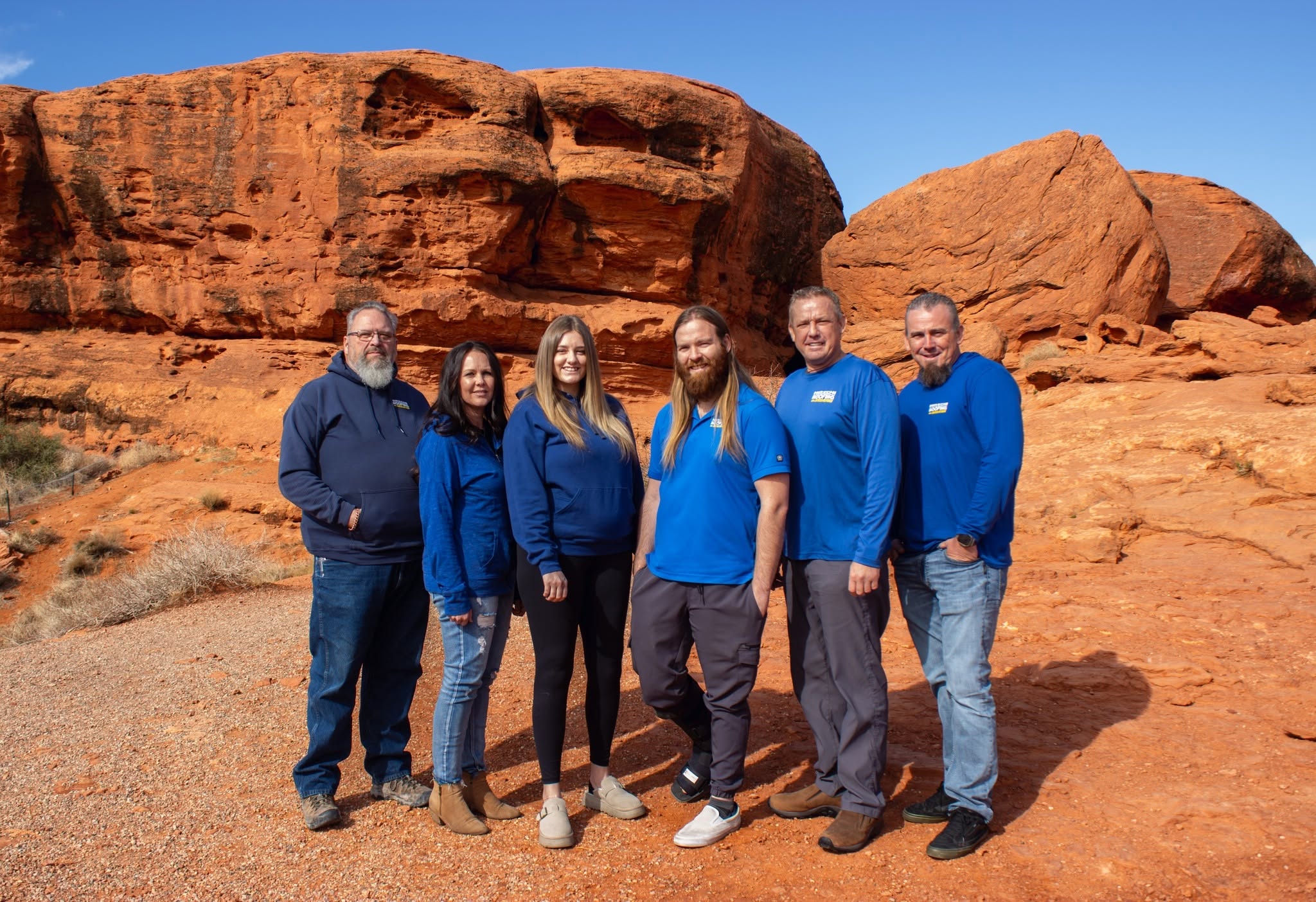 Hirschi Roofing & Insulation dedicated team standing against Southern Utah red rock cliffs
