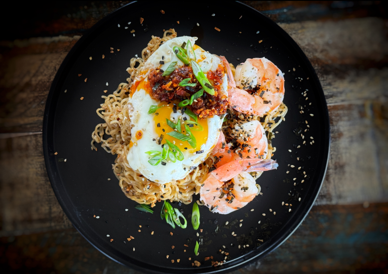 Garlic shrimp noodles topped with fried egg, scallions, and chili crisp