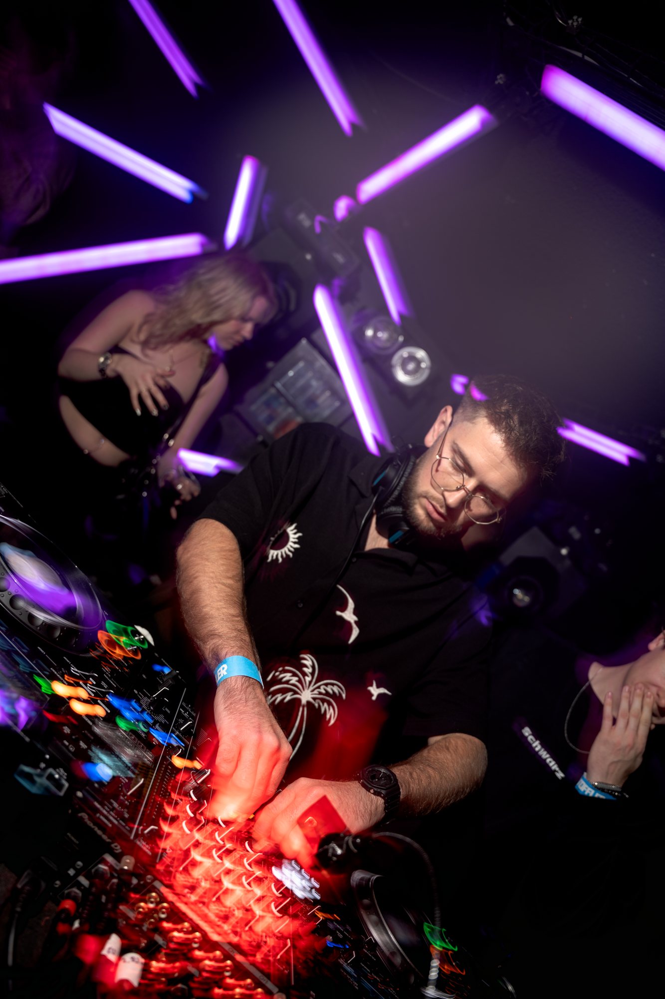 Socialice draait live in de club onder paarse lichtbuizen