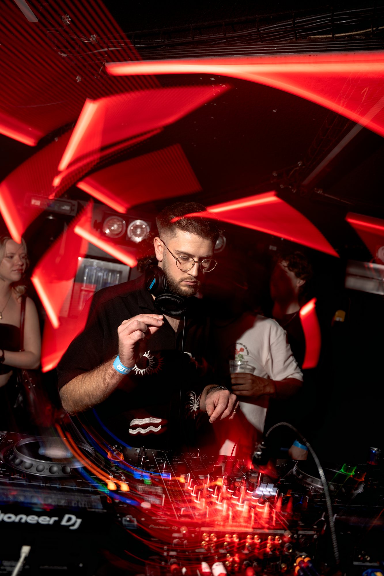Socialice draait live in de club achter de mixer met rode lichten