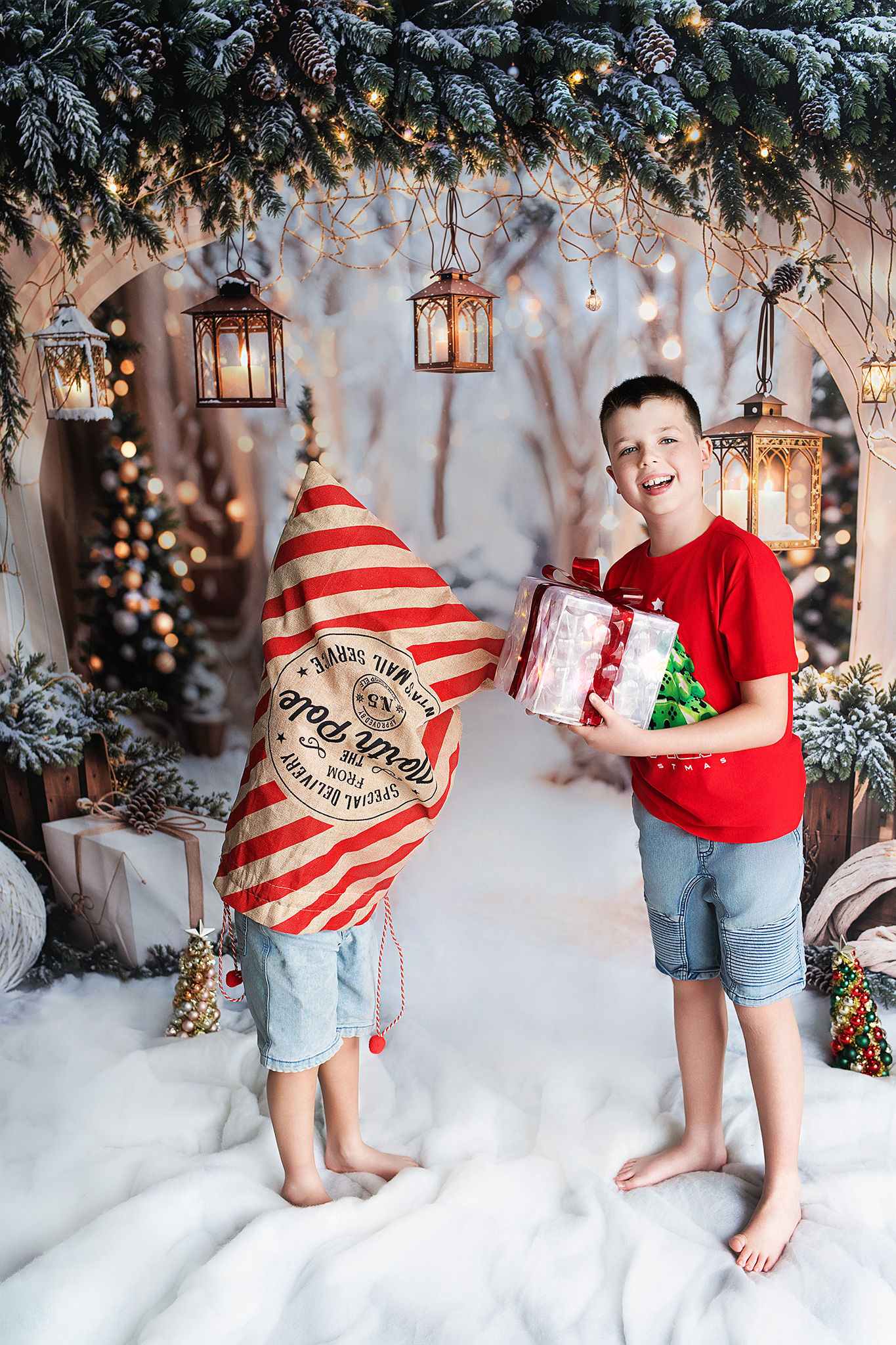 Two boys playfully posing with North Pole sack and glowing present