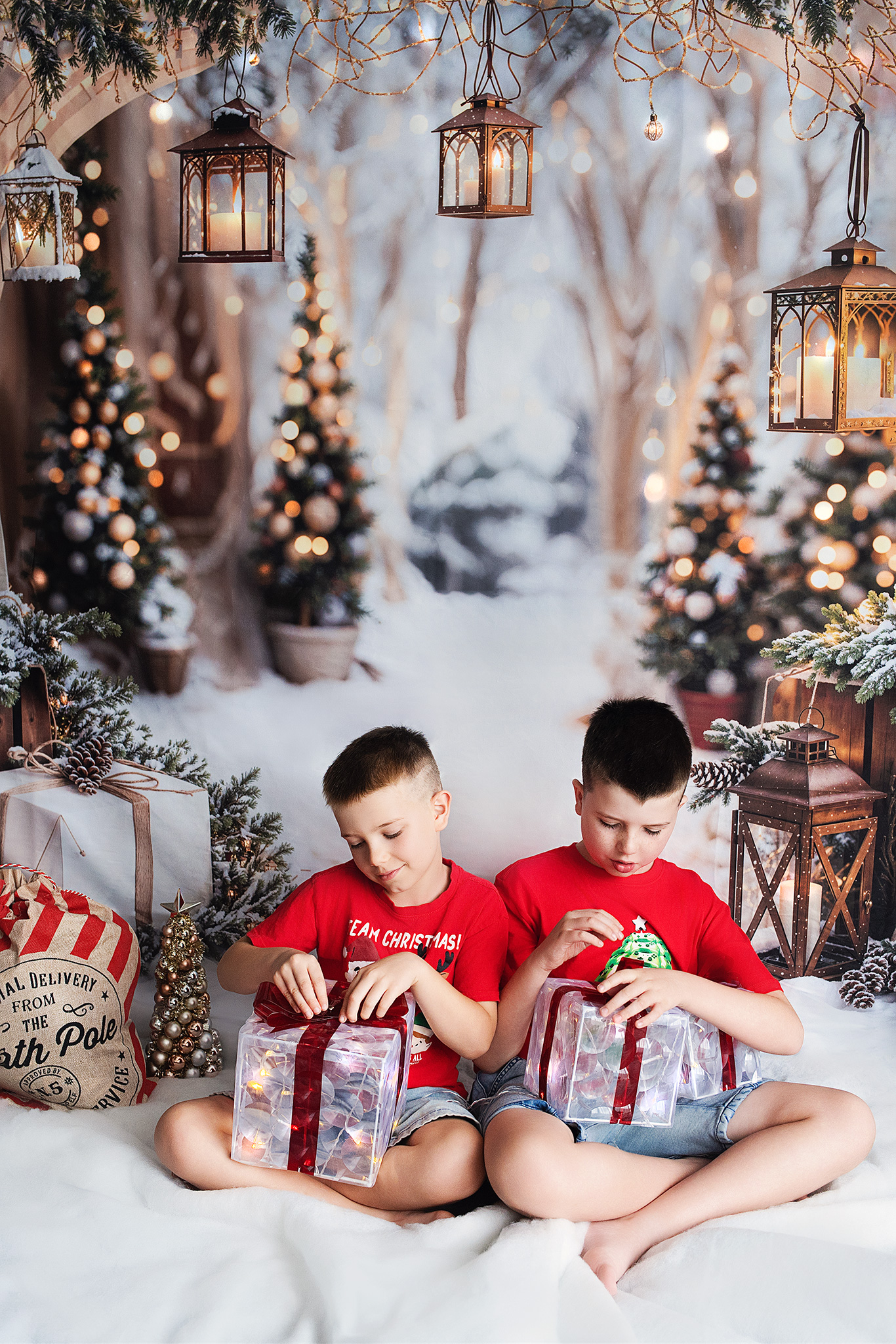 Two brothers sitting in snow opening glowing gift boxes