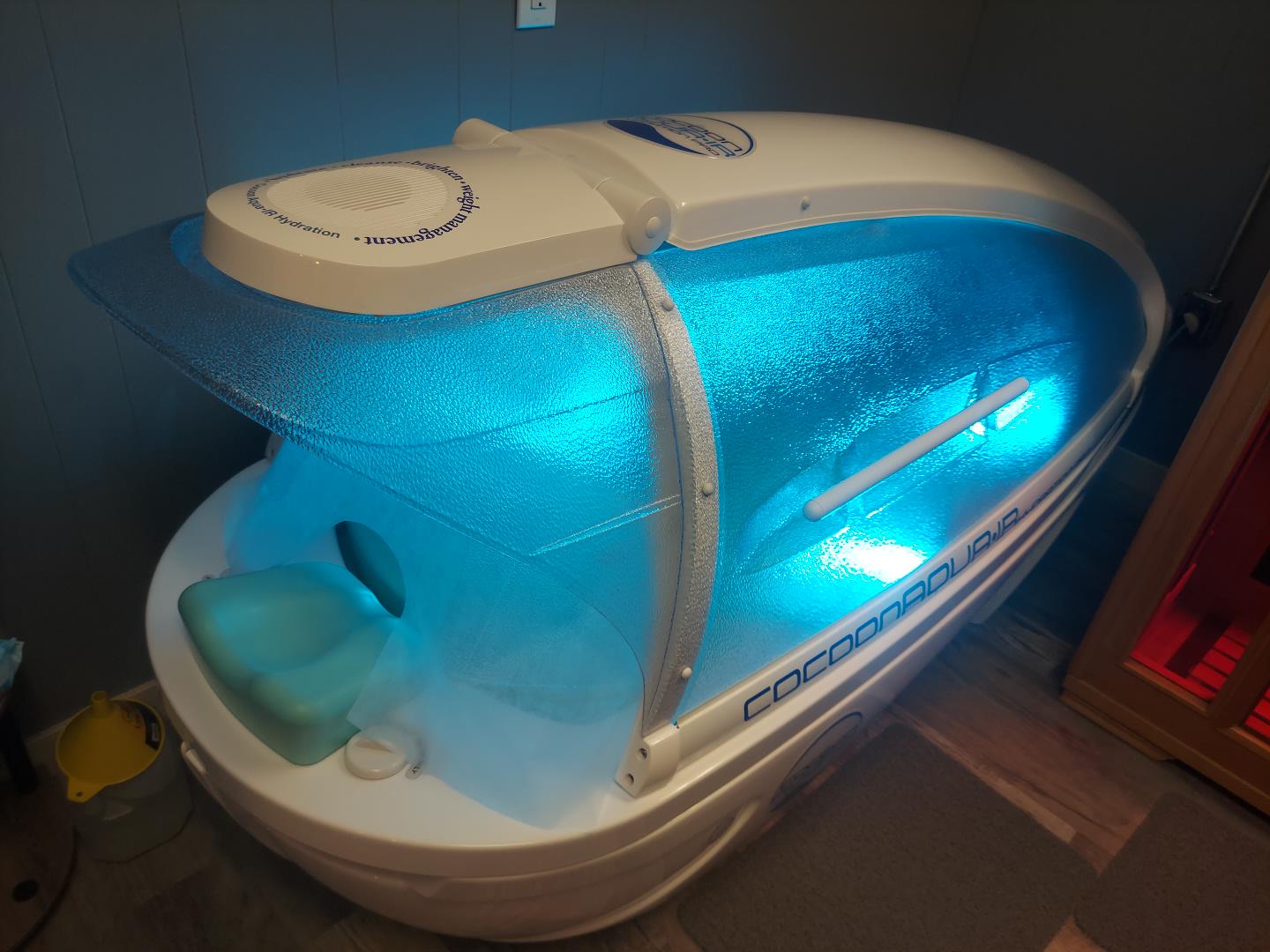 Actual Cocoon Aqua IR Wellness Pod illuminated in Vernonia Tan & Beauty spa suite