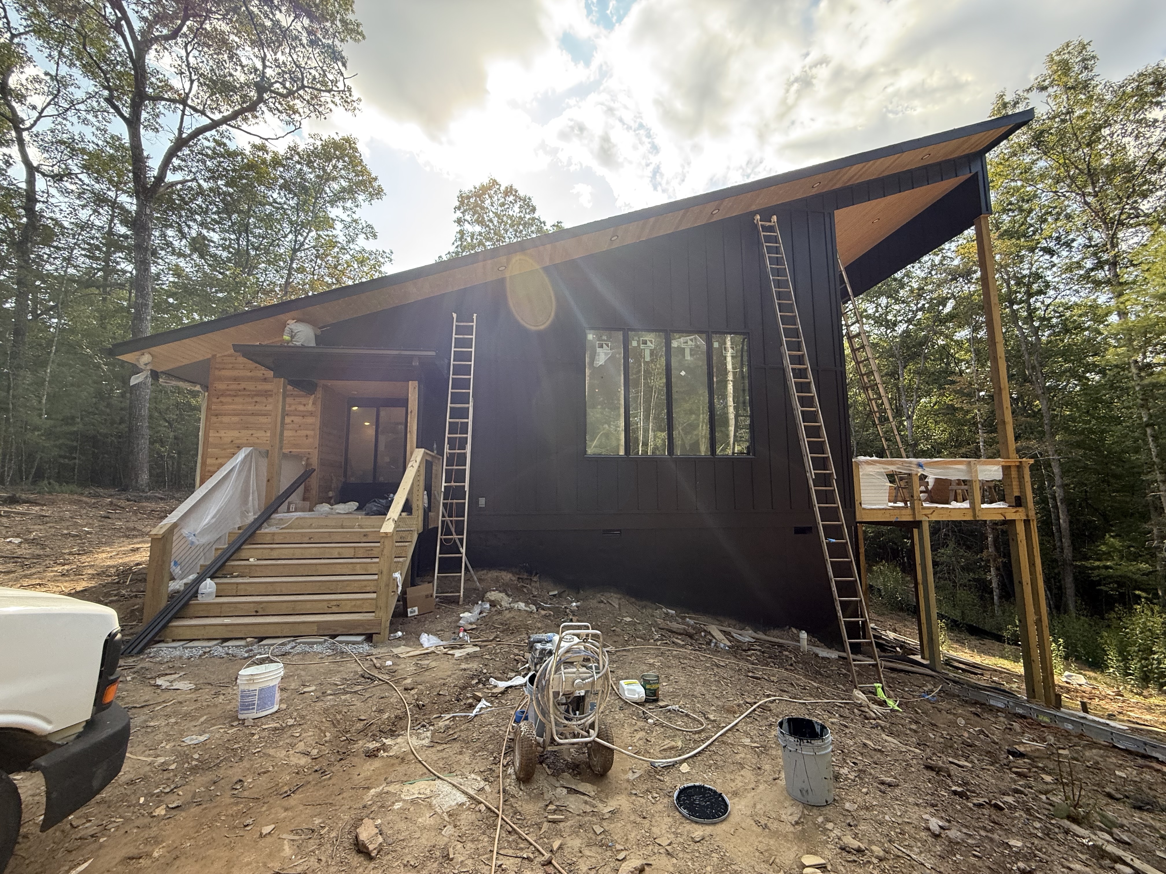 Spec home construction exterior in progress with ladders and paint equipment