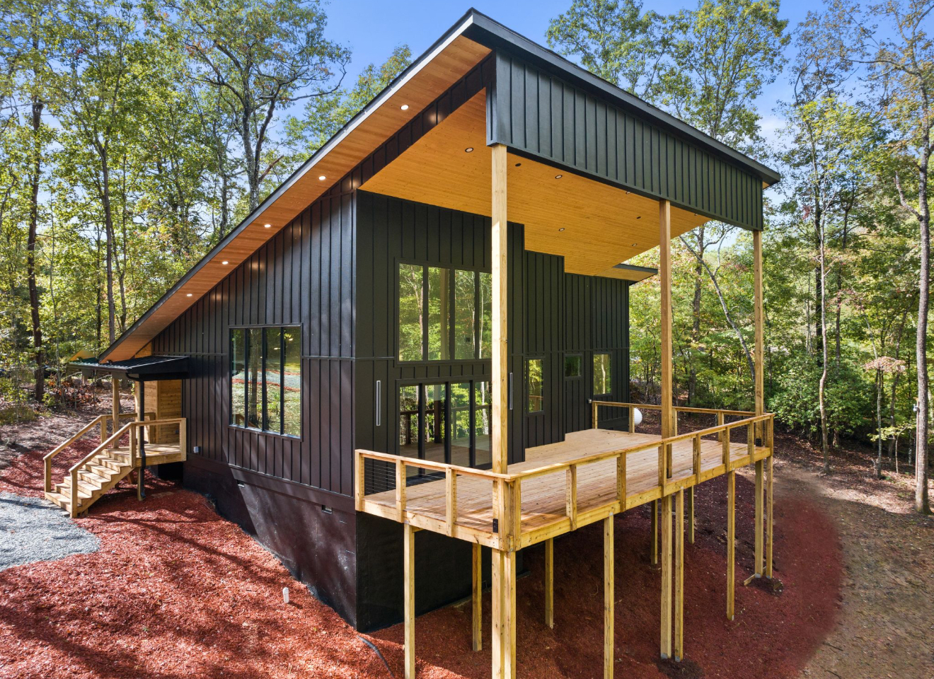 Finished modern cabin build with cantilevered roofline and elevated deck