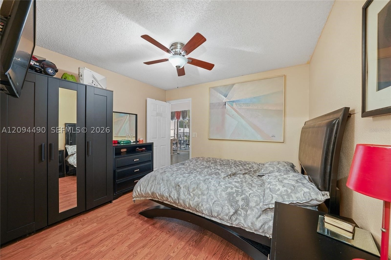 Owner primary suite bedroom with ceiling fan and en-suite bath