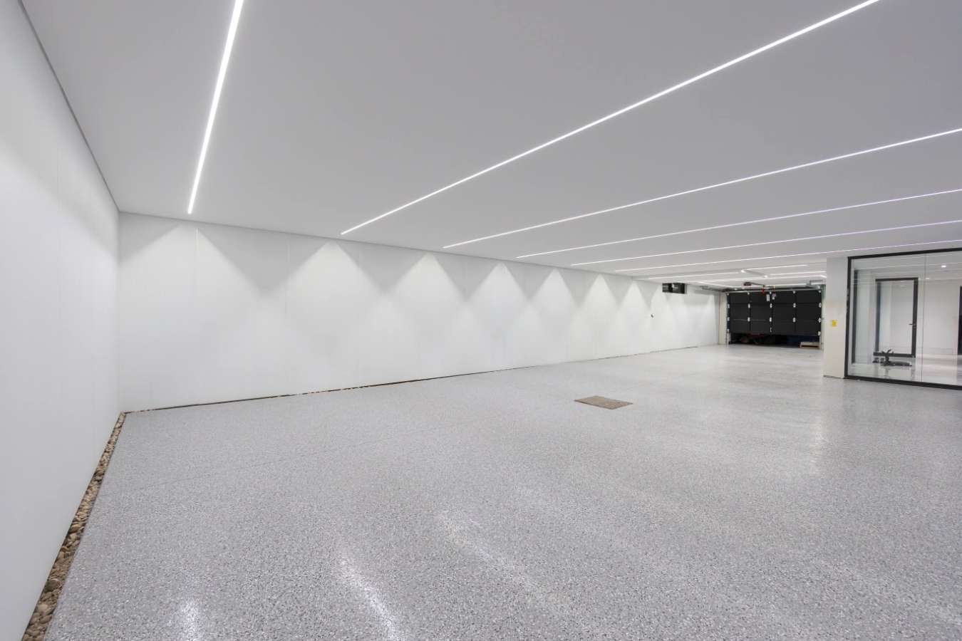 Wide-angle view of the completed gloss epoxy floor across the basement layout