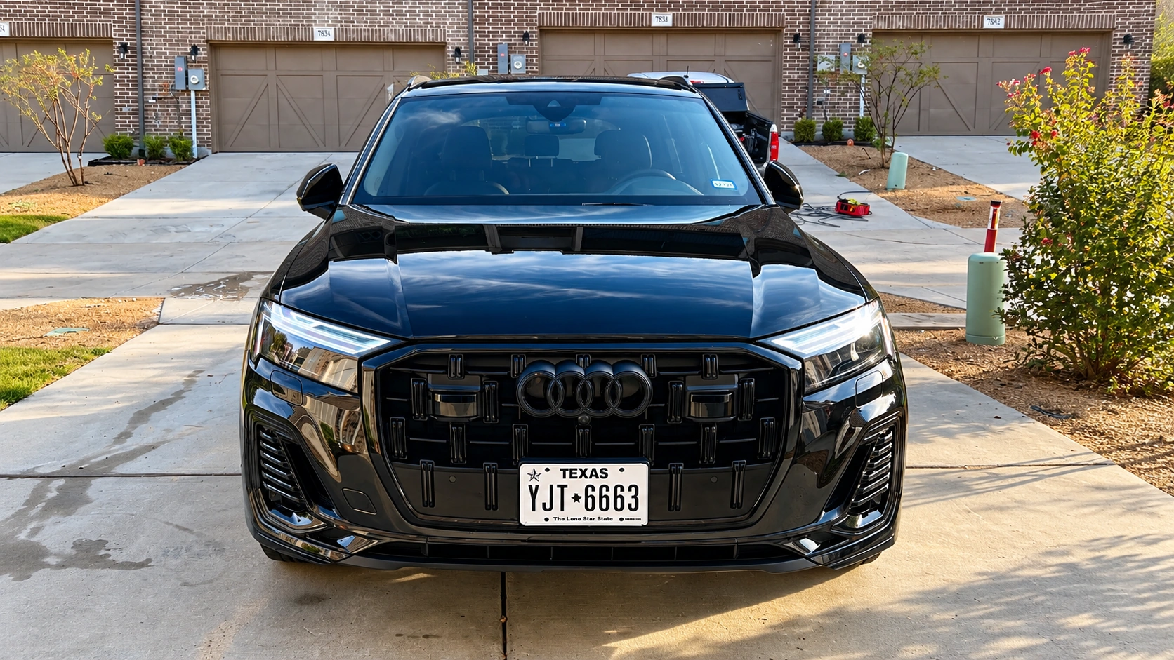 Deep gloss finish on black luxury SUV front grill and hood after exterior detailing