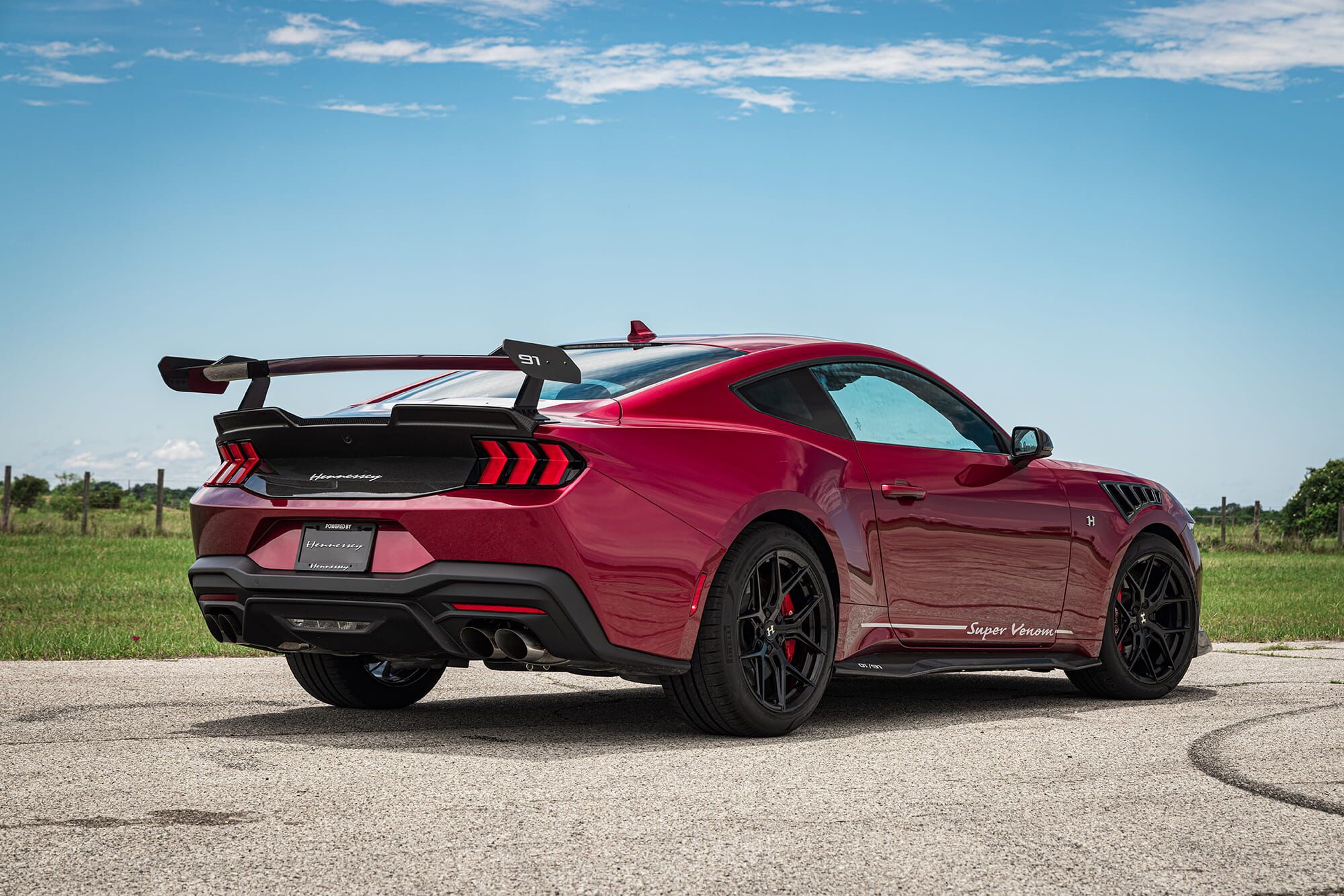 Sunset front three-quarter with carbon fiber splitter and active hood vent