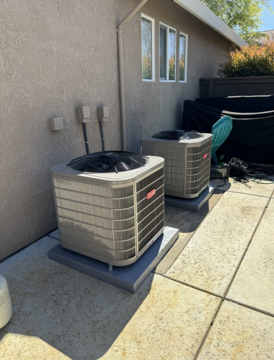 Twin Bryant outdoor AC condensers cleanly leveled on equipment pads