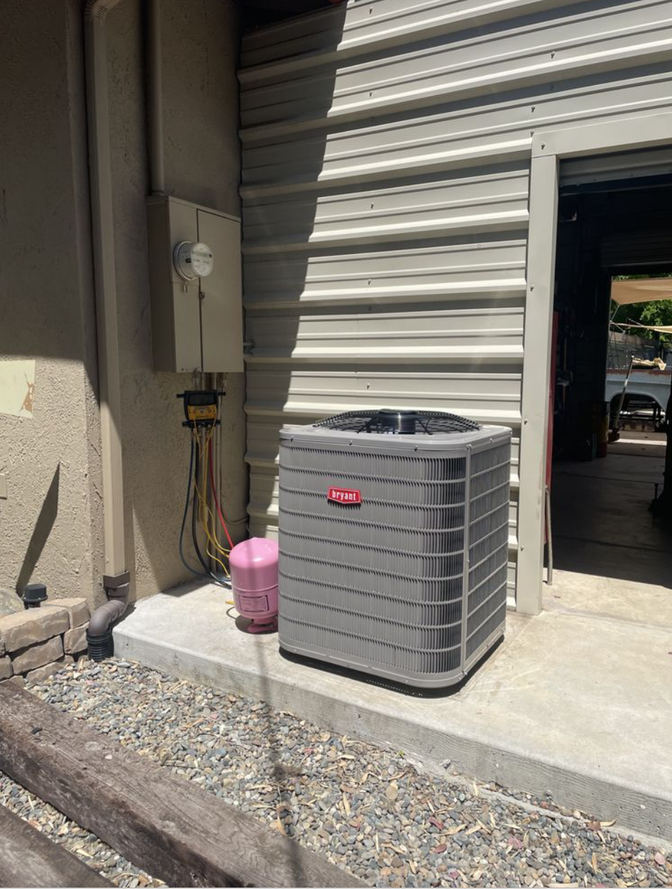 Kimber technician diagnosing a Bryant AC condenser with digital gauges