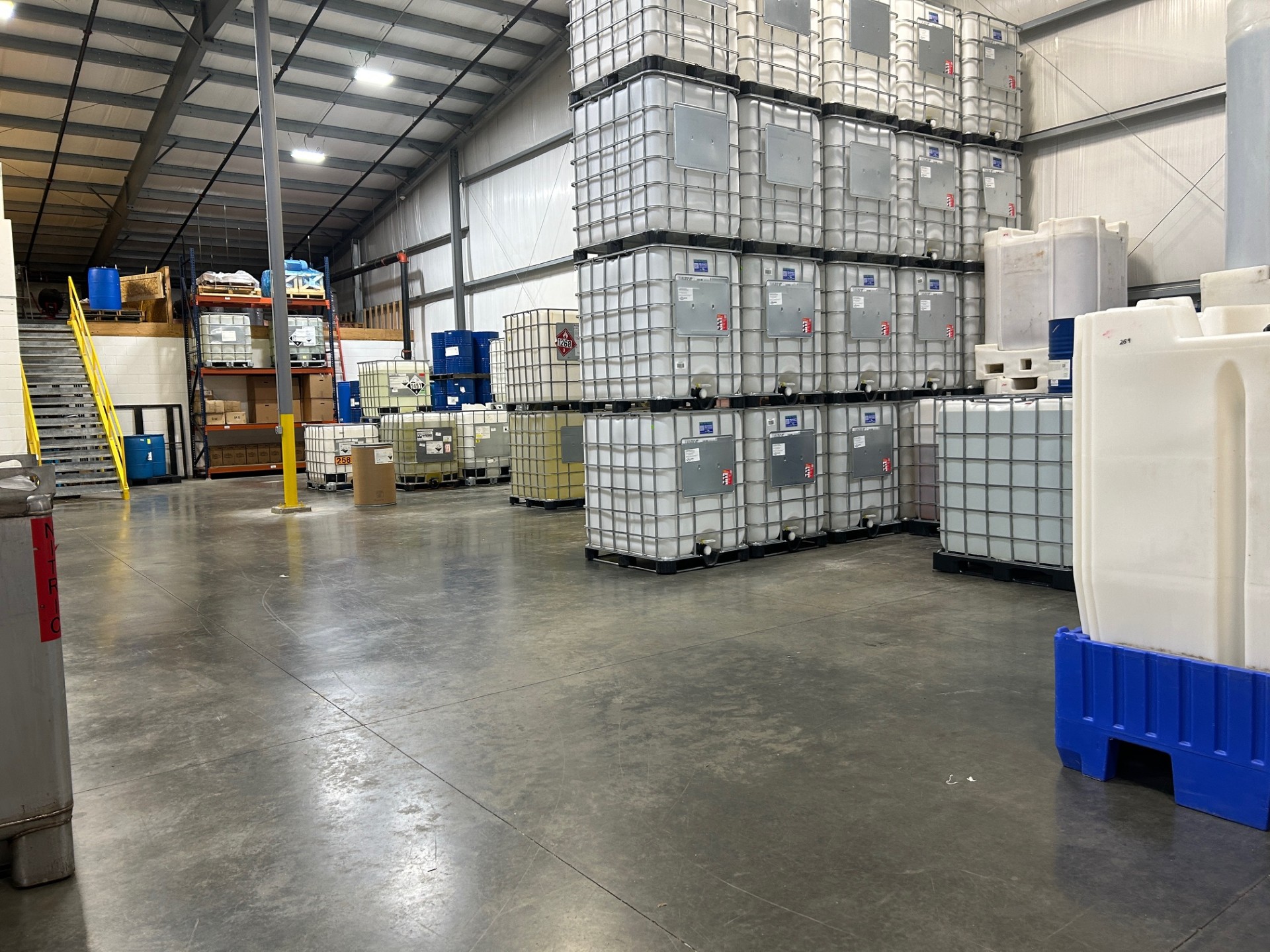 Industrial chemical warehouse with bulk IBC totes and container storage