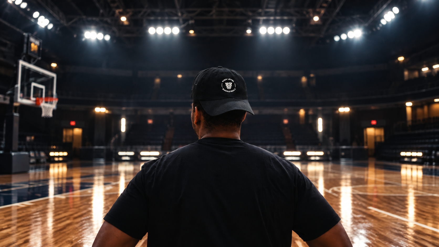 Dramatic indoor basketball arena with court spotlights, hoop, and reflective hardwood floor