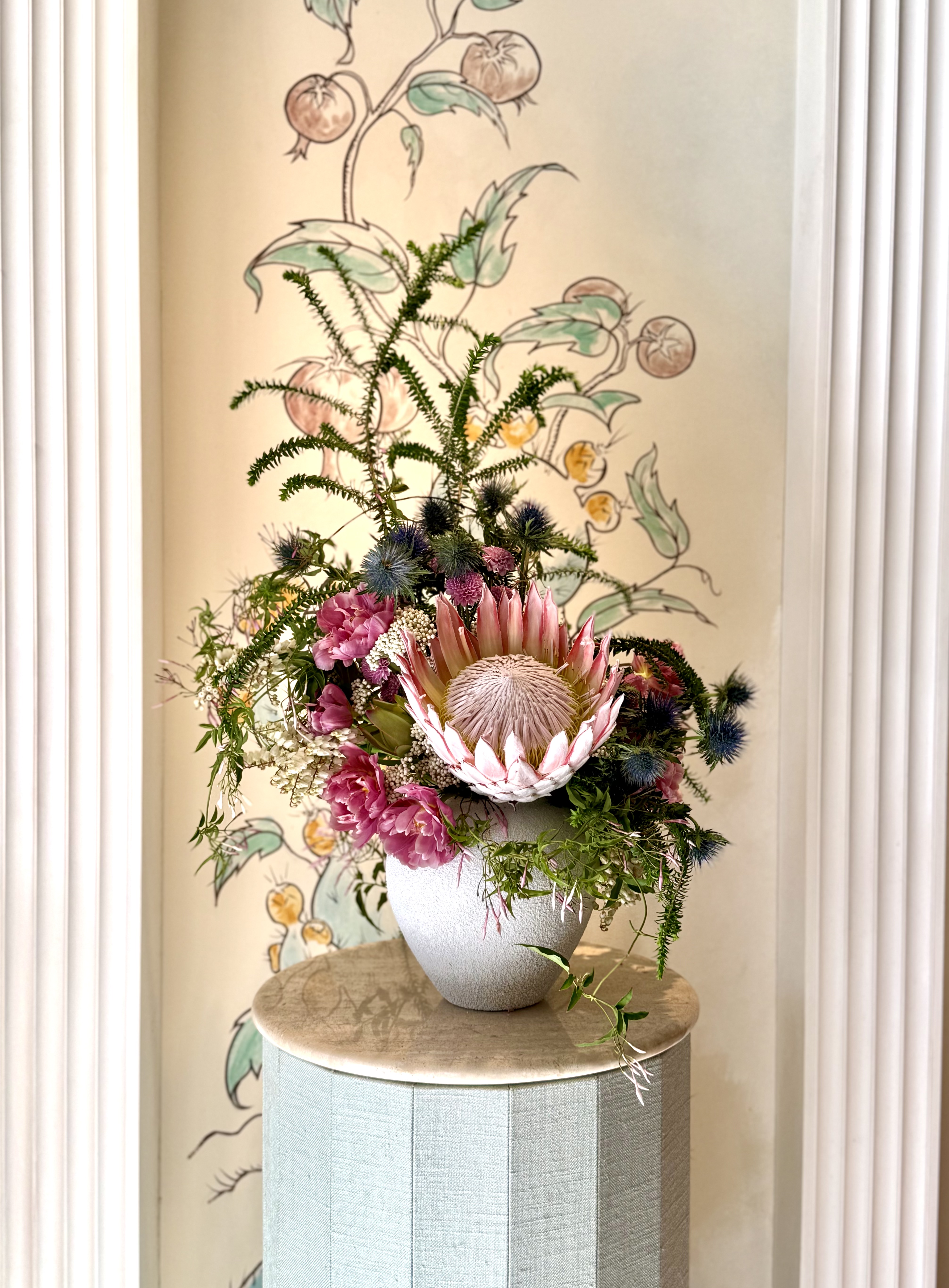 Sculptural king protea arrangement on round pedestal by Soulform Florals, Los Angeles