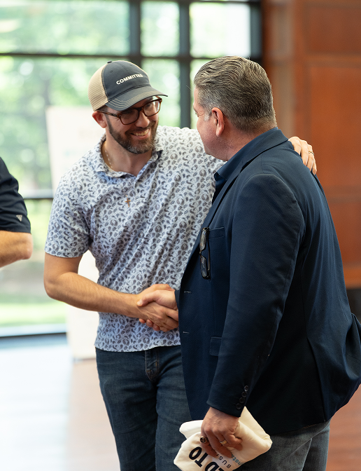 JC Hite warmly greeting and shaking hands with an attendee