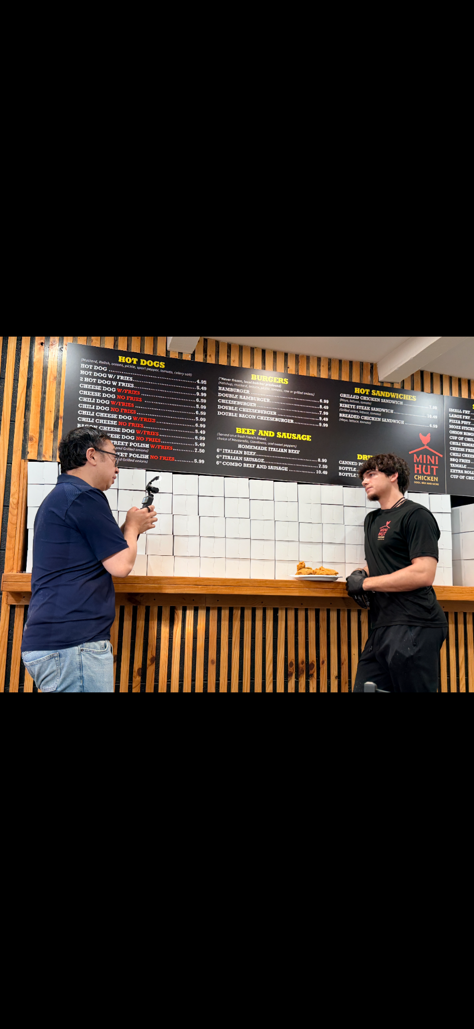 Brett at the Mini Hut counter, sharing the restaurant’s story during an interview