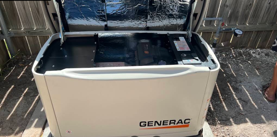 Generac standby backup generator installed on concrete pad with open access lid showing internals