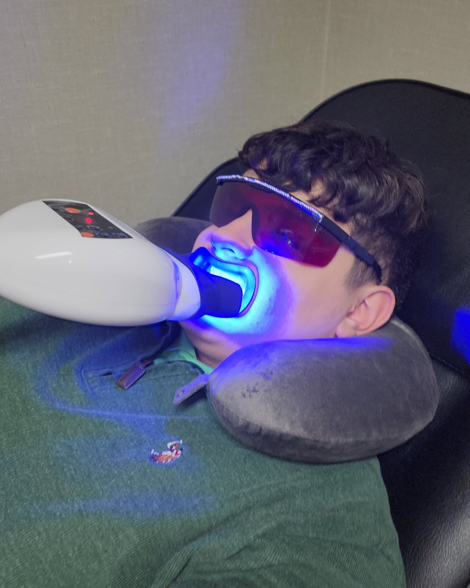Client receiving blue light LED teeth whitening treatment with protective eyewear