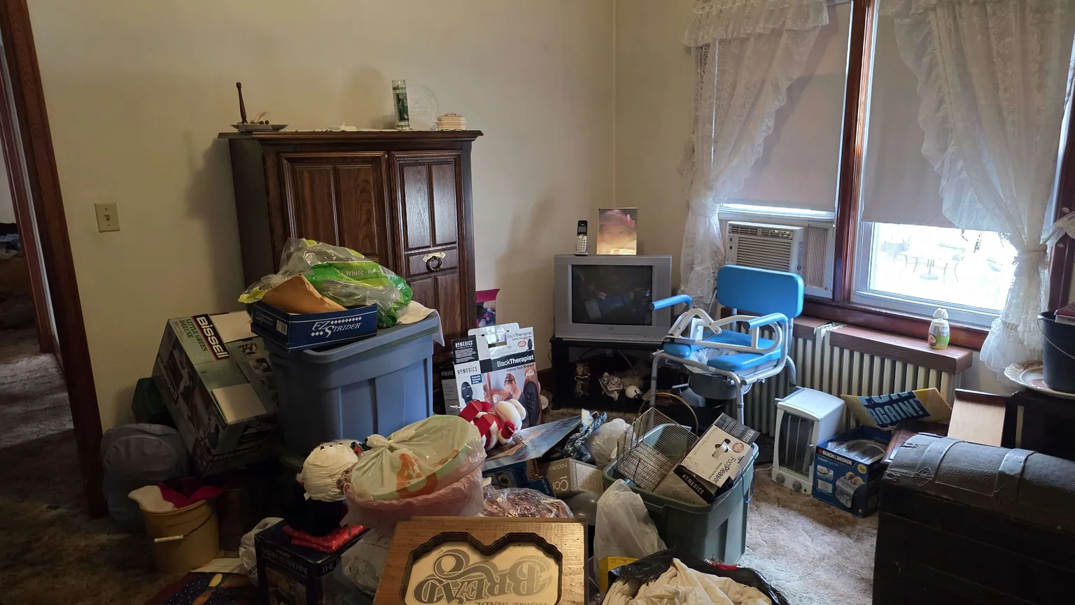 Residential room filled with furniture, storage tubs and household items during an estate cleanout in Fairfield County