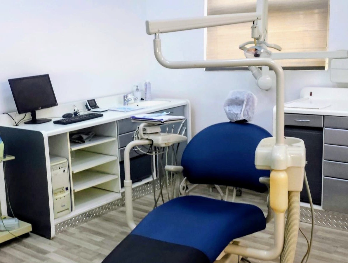 Equipped dental surgery room with blue patient treatment chair