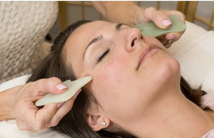 Patient receiving gentle facial gua sha therapy during a Radiance Reset session