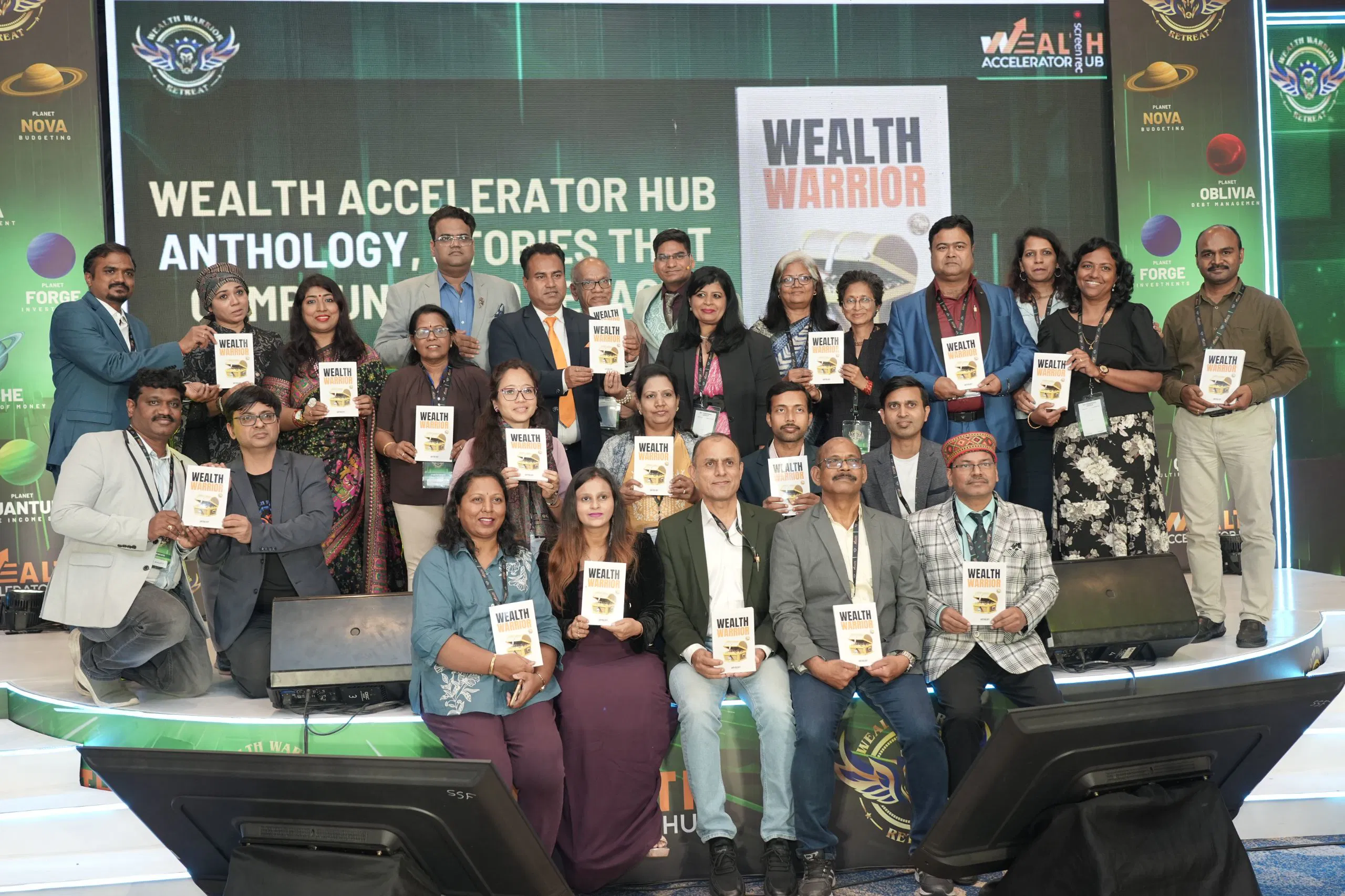 Wealth Warrior book launch stage group holding copies of Wealth Warrior Anthology at Wealth Accelerator Hub Retreat
