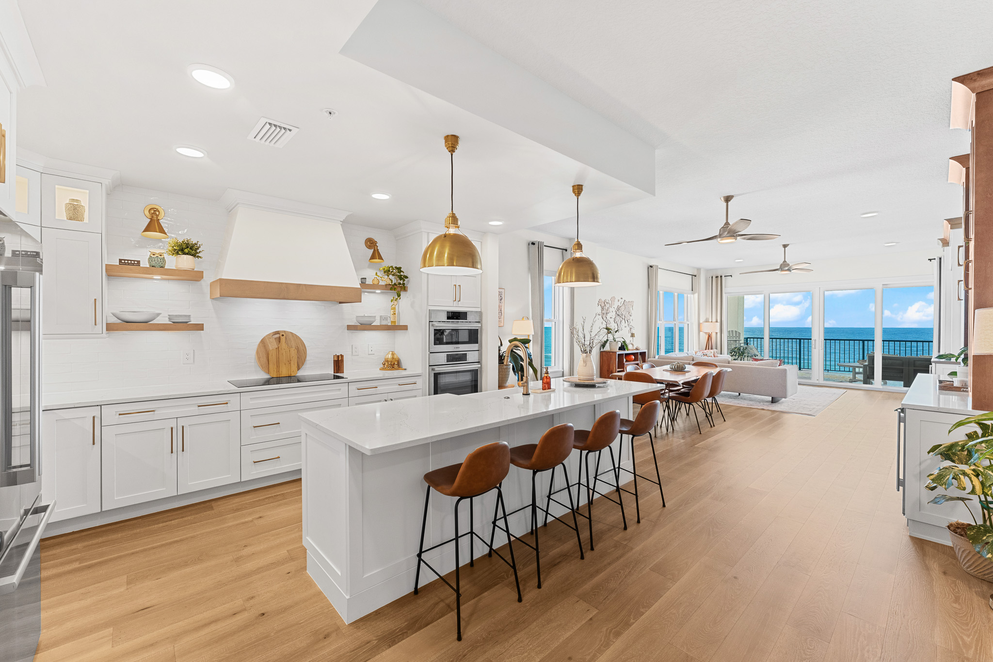 Modern luxury kitchen with island, brass pendants and ocean view