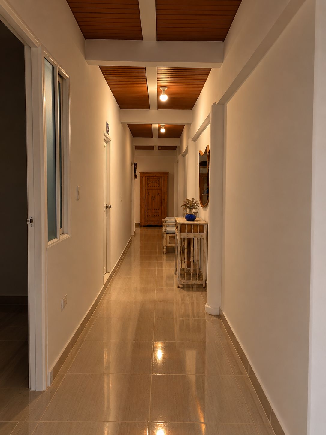 Pasillo interior con techo en madera e iluminación cálida
