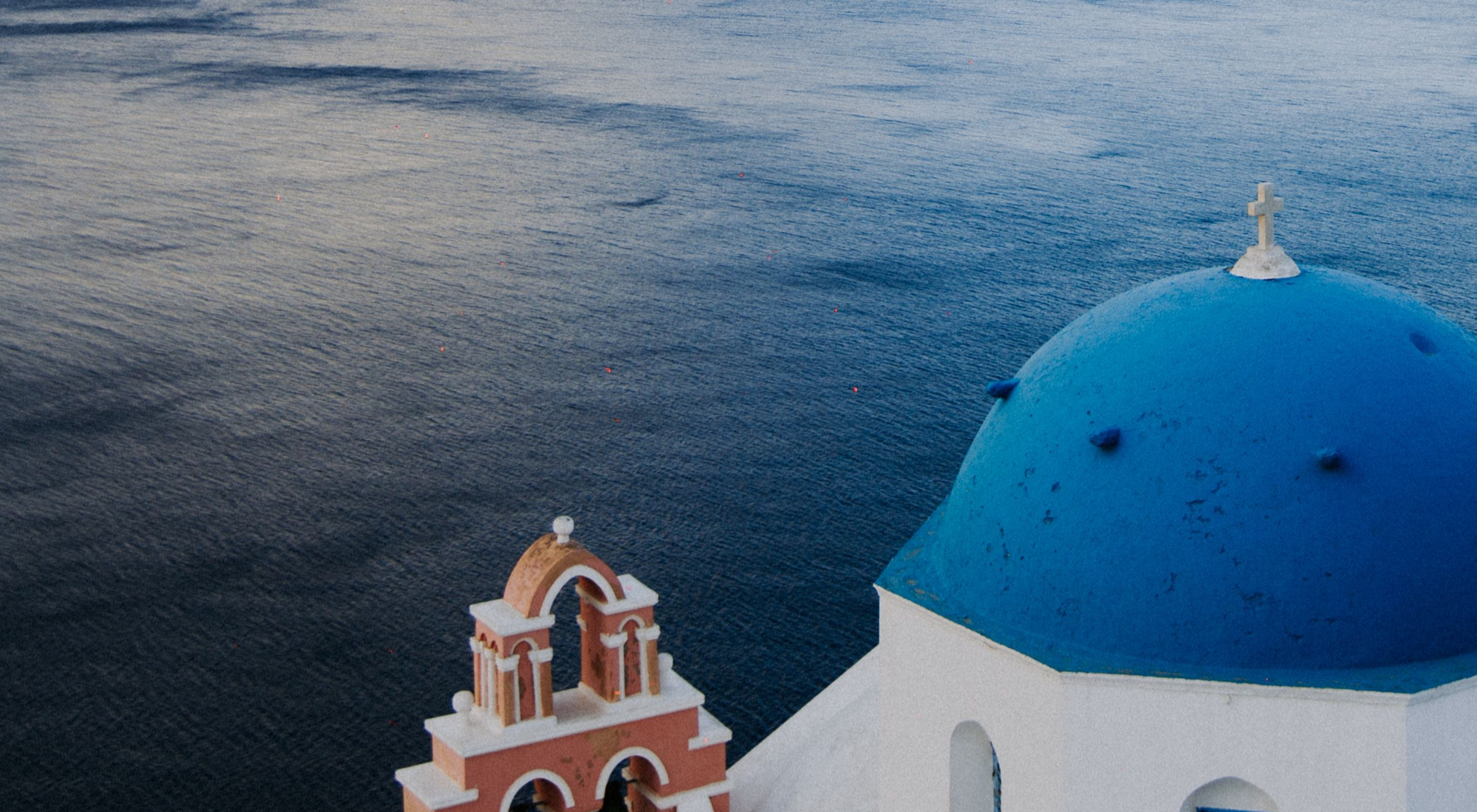 Santorini caldera and vibrant blue dome overlooking deep blue Aegean waters