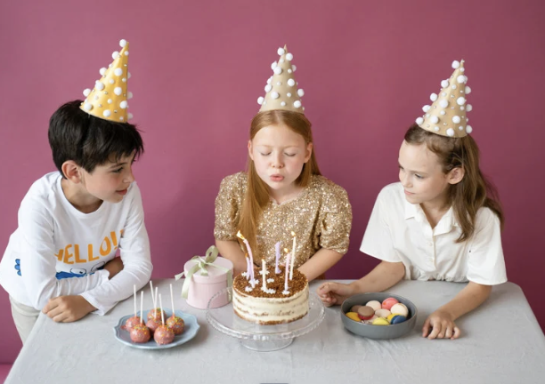 Niños con conos de fiesta y tarta de cumpleaños en Pure Jump