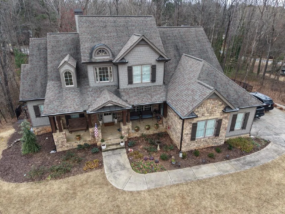 High-resolution aerial view of completed multi-gable stone estate roof replacement by Apex Roofing Solutions