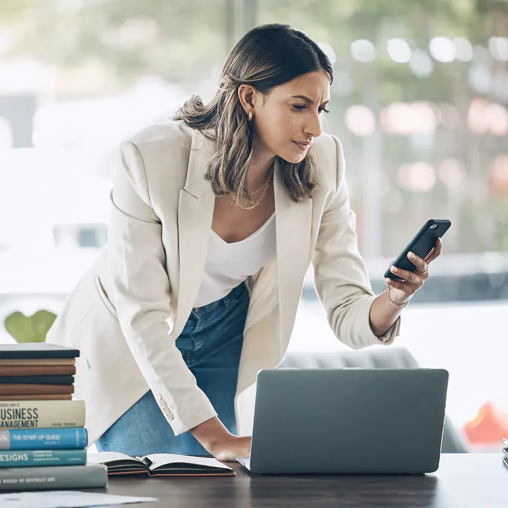 Business woman using laptop and phone